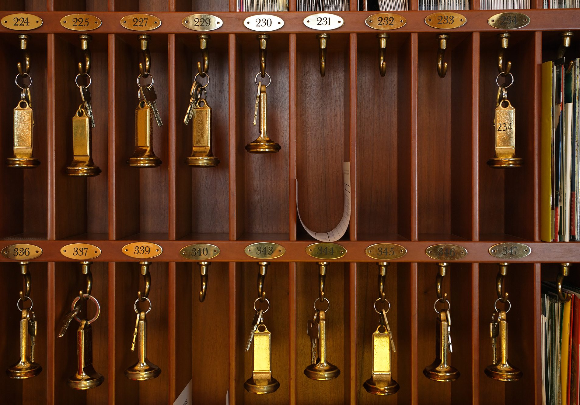 Vintage hotel front desk key rack. Focus on the top row of keys.